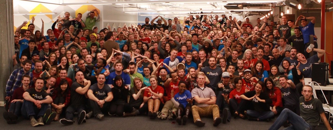 The full Porch team in Seattle, many in Porch shirts, making the roof sign with their hands