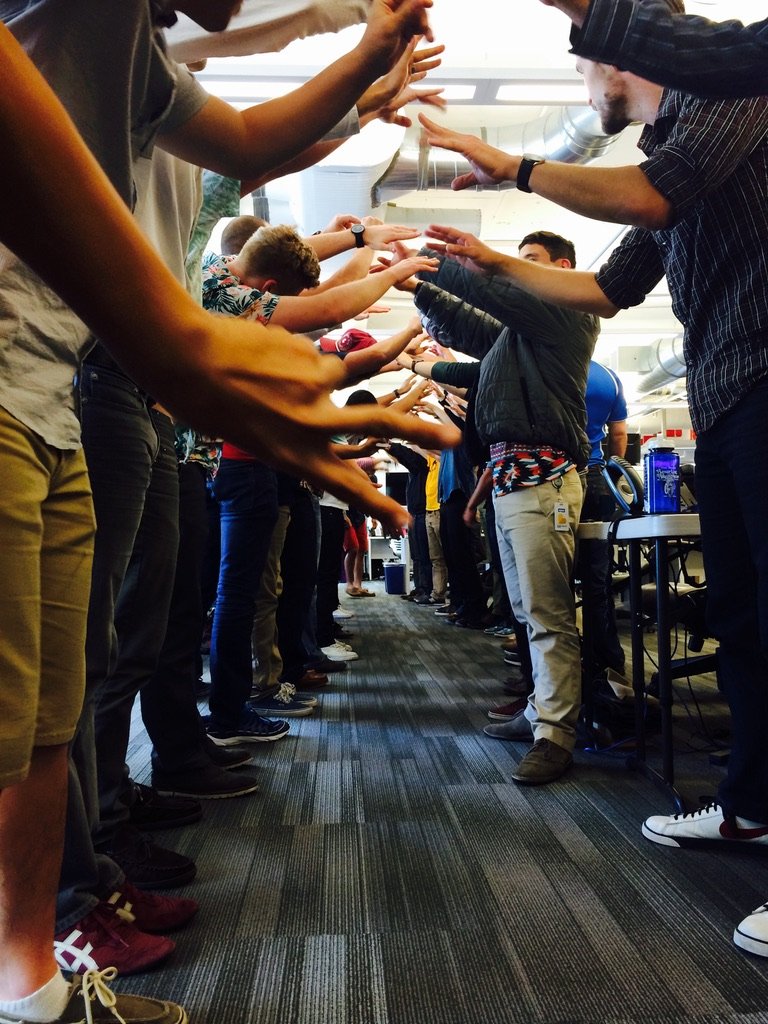 The Porch sales team forming a high-five tunnel in the office